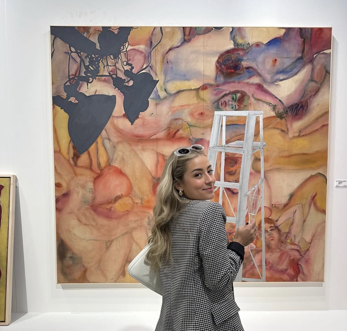 Paloma Rodriguez at an art fair, standing before a large painting
